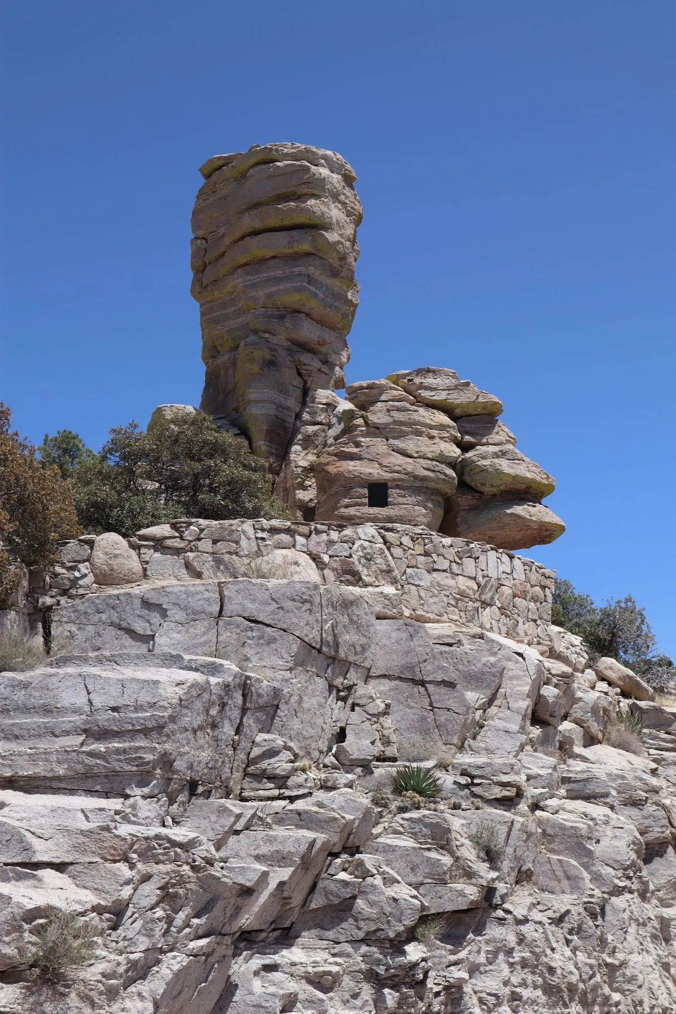 A hut carved into a stacked rock structure in the mountains. There's a window for taking photos